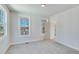 Empty bedroom with gray carpet, large windows, and a door to another room at 1274 Six Sisters St, Dacula, GA 30019