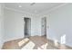 Empty bedroom with hardwood floors, white walls, and doorways to other rooms at 1274 Six Sisters St, Dacula, GA 30019