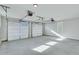 Three-car garage with white doors and concrete floor at 1274 Six Sisters St, Dacula, GA 30019
