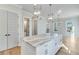 Modern kitchen with white cabinets, island, and pendant lighting at 1274 Six Sisters St, Dacula, GA 30019