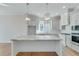 Bright kitchen with white cabinets, large island, and stainless steel appliances at 1274 Six Sisters St, Dacula, GA 30019