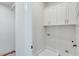 Laundry room with white cabinets and patterned tile floor at 1274 Six Sisters St, Dacula, GA 30019