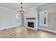 Living room with white brick fireplace, wood mantel, and chandelier at 1274 Six Sisters St, Dacula, GA 30019