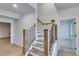 Wooden staircase with black metal balusters leading to the upper level at 1274 Six Sisters St, Dacula, GA 30019