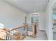 Upstairs hallway with wooden railings, carpeted floors, and a door to a balcony at 1274 Six Sisters St, Dacula, GA 30019