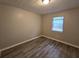 Cozy bedroom with window, wood-look flooring, and neutral walls at 4793 White Oak Path, Stone Mountain, GA 30088