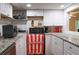 Basement kitchen with white cabinets, granite counters, and stainless steel appliances at 784 Lake Dr, Snellville, GA 30039