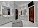 Elegant Primary bath with double vanities, a large soaking tub, and marble floors at 962 Chattooga Trce, Suwanee, GA 30024