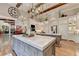 Open kitchen boasts a large island, marble countertops, and rustic wood beams at 962 Chattooga Trce, Suwanee, GA 30024