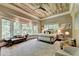 Luxurious main bedroom with a tray ceiling, ample natural light and relaxing sitting area at 962 Chattooga Trce, Suwanee, GA 30024