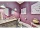 Stylish powder room with purple walls and unique art at 962 Chattooga Trce, Suwanee, GA 30024