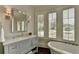 Elegant bathroom with soaking tub, quartz vanity, and plantation shutters at 962 Chattooga Trce, Suwanee, GA 30024