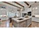Open kitchen with large island, marble countertops, and rustic wood beams at 962 Chattooga Trce, Suwanee, GA 30024