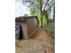 Brown outbuilding with a gravel driveway and tree backdrop at 2023 Lee Dr, Austell, GA 30168