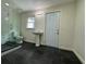 Modern bathroom with pedestal sink, walk-in shower, and dark tile floors at 2023 Lee Dr, Austell, GA 30168