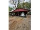 Red carport with a gravel area and a white trailer parked inside at 2023 Lee Dr, Austell, GA 30168