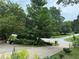 Landscaped front yard with a paved driveway and mature trees at 2023 Lee Dr, Austell, GA 30168