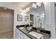 Double vanity bathroom with dark countertop and walk-in closet at 2535 Riverside Rd, Conyers, GA 30013