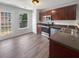 Kitchen with stainless steel appliances, dark wood cabinets, and a door leading to the backyard at 313 Lauren Dr, Fairburn, GA 30213