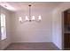 Empty dining room with modern chandelier and hardwood floor at 221 Bridgemill Ln, Hampton, GA 30228