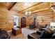 Rustic living room with wood walls, stone fireplace, and leather furniture at 3992 Doc Sams Rd, Cumming, GA 30028