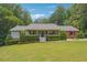 Ranch-style home with covered porch, brick accents, and landscaped yard at 3992 Doc Sams Rd, Cumming, GA 30028