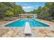 Inviting swimming pool with diving board and flagstone patio at 3992 Doc Sams Rd, Cumming, GA 30028