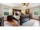 Main bedroom with hardwood floors, large bed, and ceiling fan at 3992 Doc Sams Rd, Cumming, GA 30028
