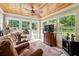 Relaxing sunroom with hardwood floors, a ceiling fan, and views of the backyard at 3992 Doc Sams Rd, Cumming, GA 30028
