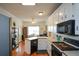 Galley kitchen with white cabinets, stainless steel appliances, and hardwood floors at 37 Red Fox Trl, Euharlee, GA 30145