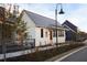 White cottage with gray metal roof and peach front door at 52 Spirea Way, Auburn, GA 30011