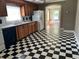 Checkerboard floor kitchen with wood cabinets and view to living room at 2203 Hillcrest Ave, Decatur, GA 30032