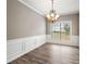Bright dining room features hardwood floors, wainscoting, and a chandelier at 320 Pintail Ct, Suwanee, GA 30024