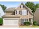 Two-story house with tan siding, white garage door, and dark shutters at 320 Pintail Ct, Suwanee, GA 30024