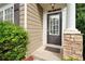 House entrance with dark door, stone pillars, and landscaping at 320 Pintail Ct, Suwanee, GA 30024