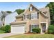 Two-story house with tan siding, white garage door, and dark shutters at 320 Pintail Ct, Suwanee, GA 30024