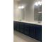Double vanity bathroom with navy cabinets and quartz countertops at 2404 Anhinga Dr, Loganville, GA 30052