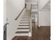 Elegant staircase with wooden railings and dark hardwood floors at 1641 Lacebark Elm Way, Lawrenceville, GA 30045