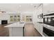 Open concept kitchen with island, stainless steel appliances, and view to Gathering room at 1641 Lacebark Elm Way, Lawrenceville, GA 30045