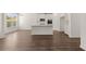 Open kitchen with white cabinets, island, and hardwood floors at 1641 Lacebark Elm Way, Lawrenceville, GA 30045