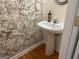 Small powder room with pedestal sink and patterned wall at 4870 Hairston Park Sq, Stone Mountain, GA 30083