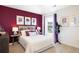 Stylish bedroom with a white bed and a dramatic burgundy accent wall at 12000 Conrad Cir, Hampton, GA 30228
