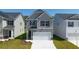 Two-story gray house with a white garage door and landscaping at 12000 Conrad Cir, Hampton, GA 30228