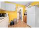 Bright yellow kitchen with white cabinets and appliances at , Atlanta, GA 30318
