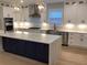 Kitchen featuring white cabinets, navy island, stainless steel appliances, and quartz countertops at 408 Autry St, Norcross, GA 30071