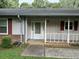 Front entrance with a white door, red shutters, and a small porch at 1799 Brandy Woods Se Trl, Conyers, GA 30013