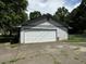 Detached garage with a white door and gravel driveway at 1799 Brandy Woods Se Trl, Conyers, GA 30013