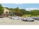 Spacious parking lot with cars parked, clubhouse in background at 376 Cattlemans Cir, Mcdonough, GA 30252