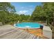 Inviting above ground pool with wooden deck and surrounding trees at 376 Cattlemans Cir, Mcdonough, GA 30252