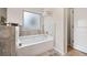 Relaxing bathroom with soaking tub and frosted window at 5410 Whisper Ct, Cumming, GA 30028